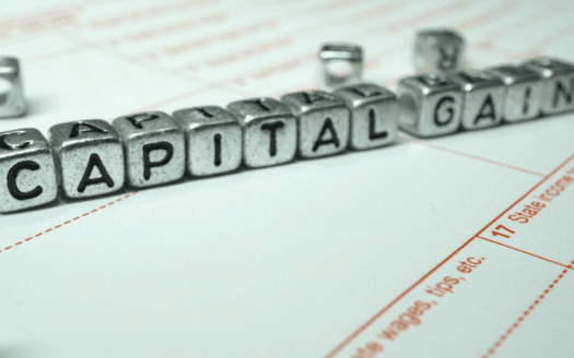 metal letter blocks spelling capital gain on a tax form representing capital gains tax on real estate