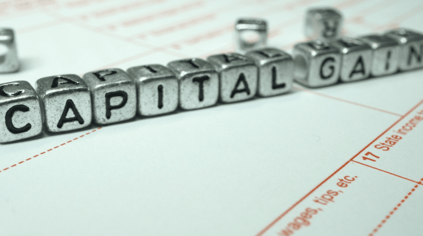 metal letter blocks spelling capital gain on a tax form representing capital gains tax on real estate